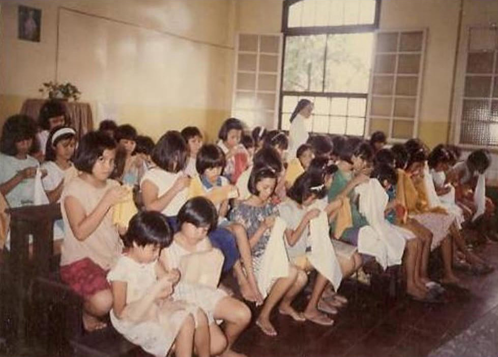 Historical photograph of residents engaged in hand embroidery